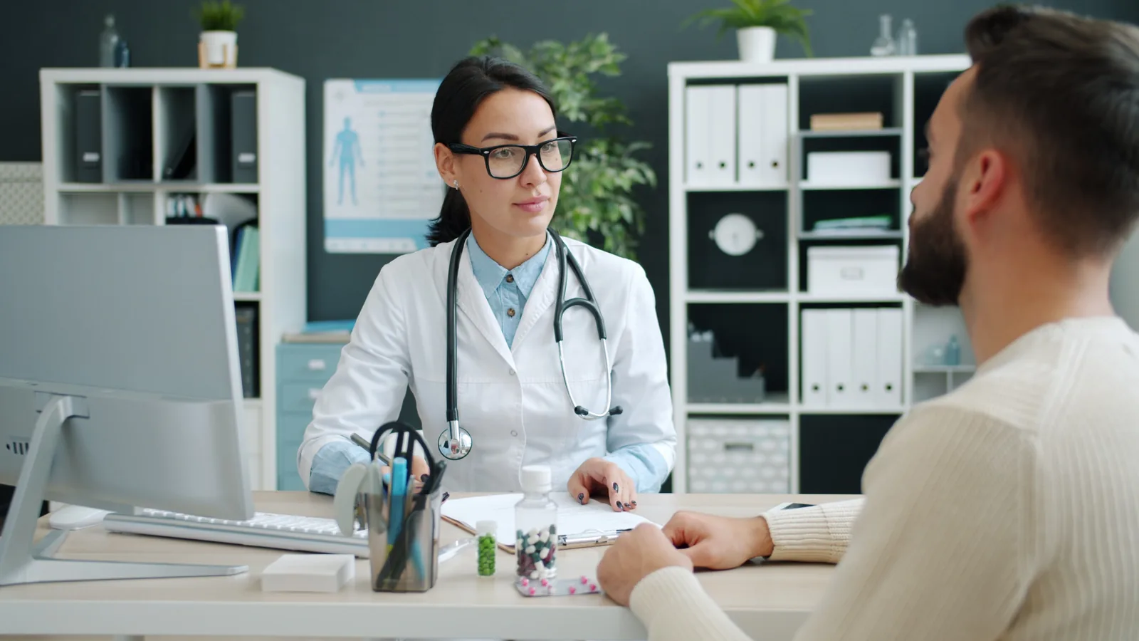 Doctor speaking with a patient across a clinic desk