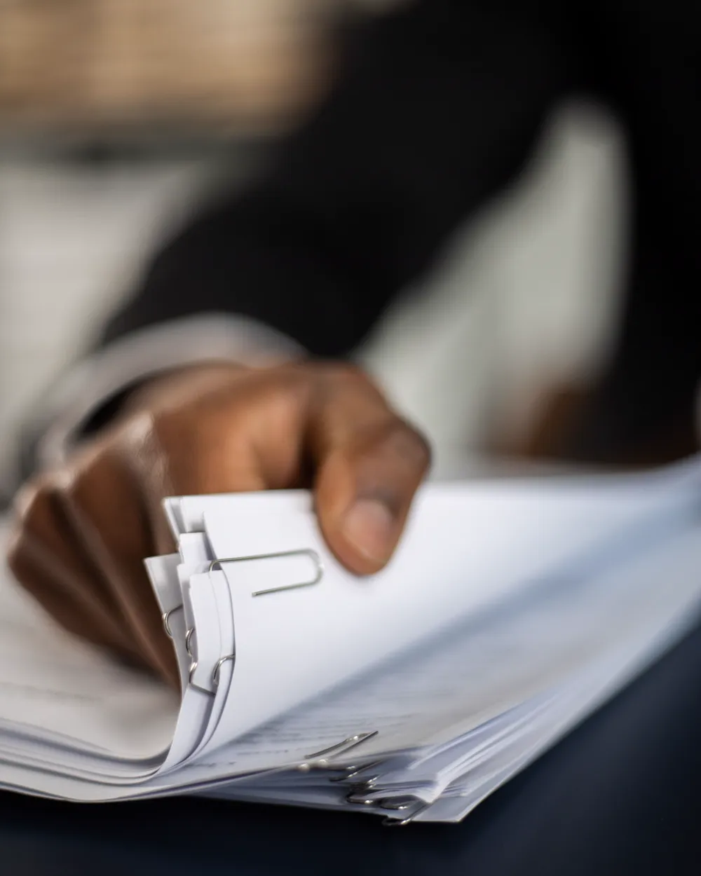 Hand sorting a stack of paper-clipped records