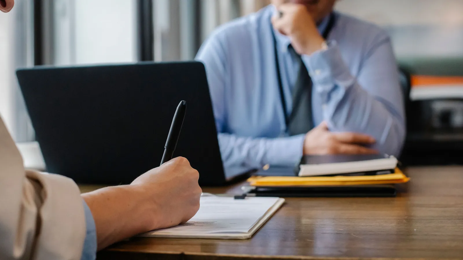 Job applicant completing paperwork across from an interviewer