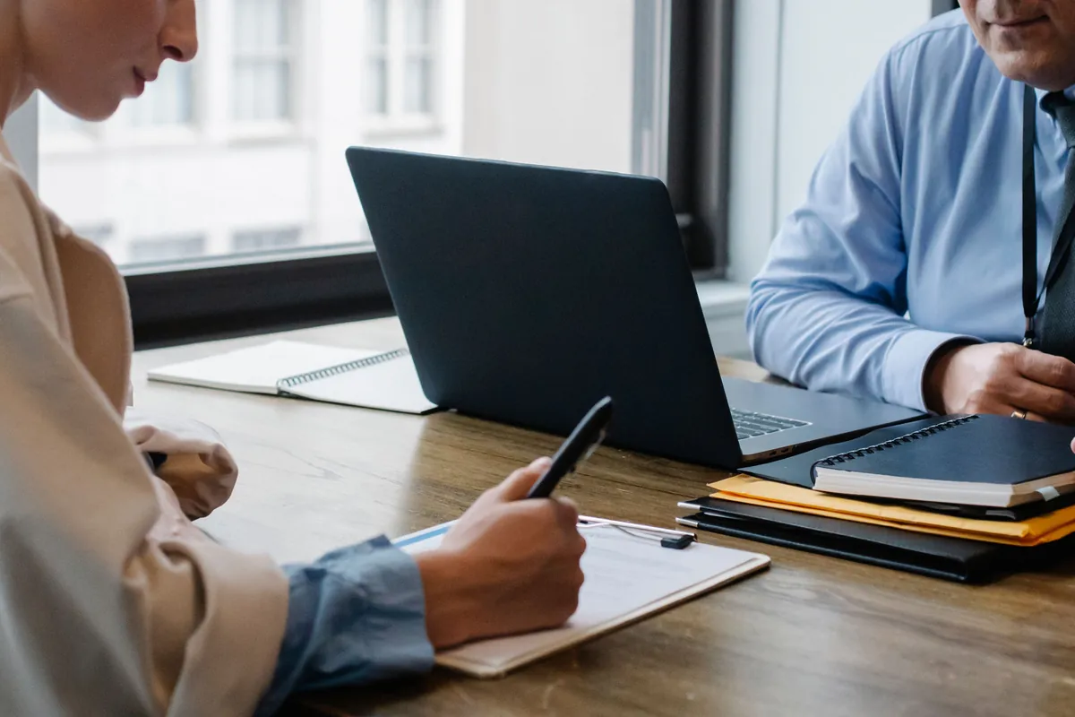 Applicant signing employment paperwork during an office meeting
