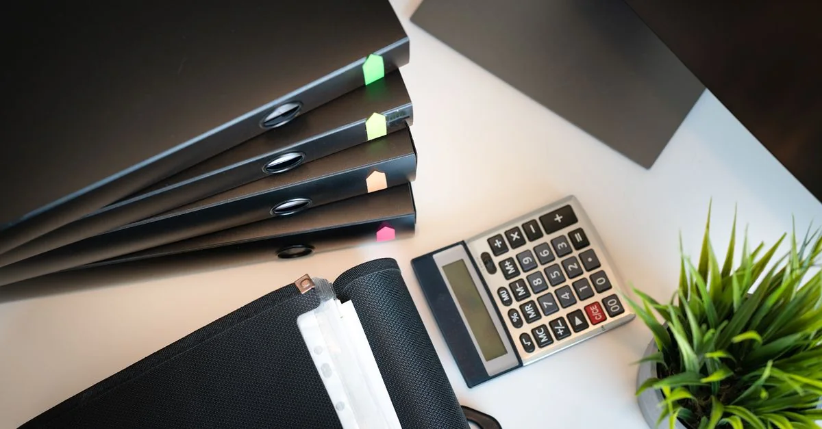 File folders and a calculator arranged on a desk