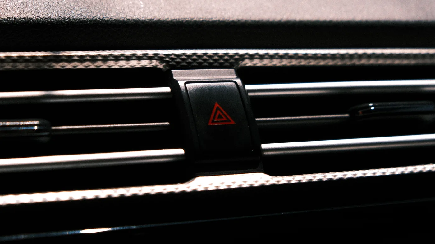 Close-up of the red hazard light button on a car dashboard