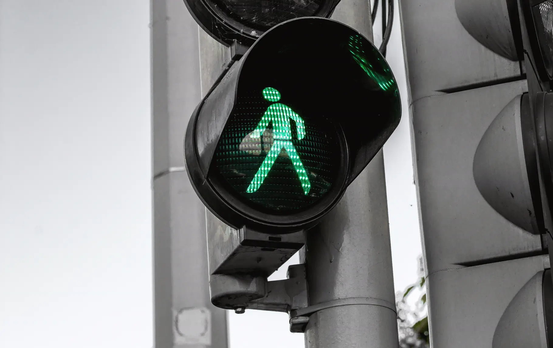 Green pedestrian crossing signal mounted on a streetlight pole