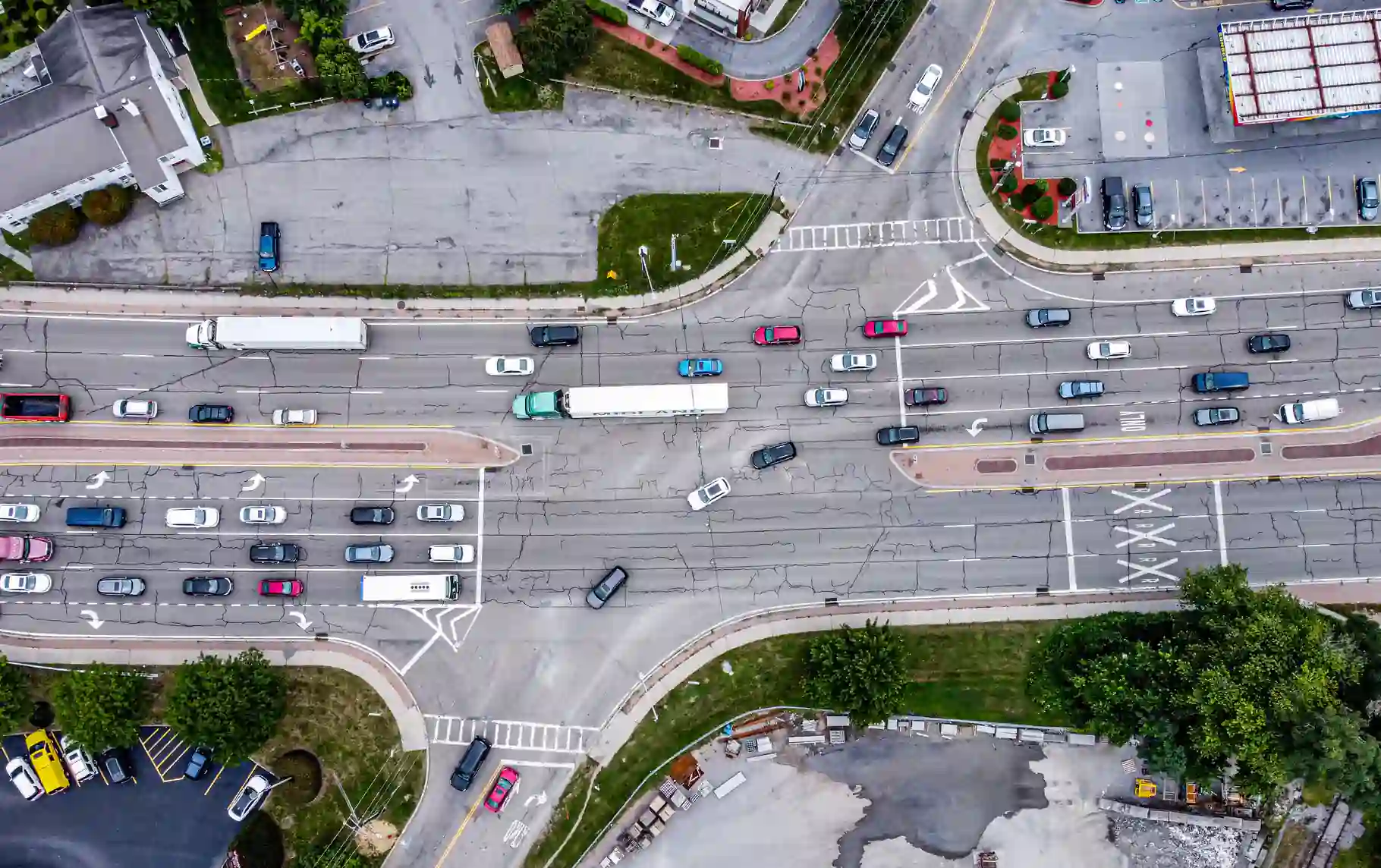 Aerial view of commercial trucks and cars traveling through a multi-lane intersection